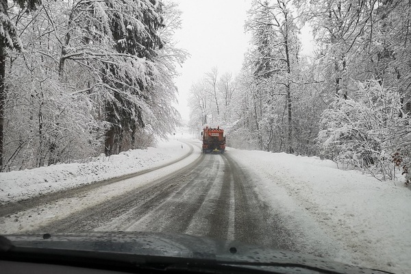 Winterdienstfahrzeug r&auml;umt Schnee auf einer Stra&szlig;e und streut.
